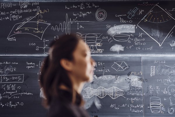 CoG PhD student Guangzi Xu photographed in front of a blackboard at the Niels Bohr Instiute